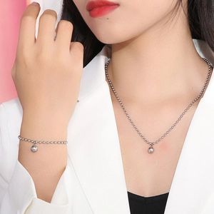 Polished stainless steel ball chain necklace and bracelet set worn by a fashion model