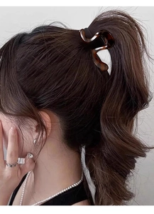 Side view of a medium brown tortoiseshell wave hair claw clip securing a high ponytail