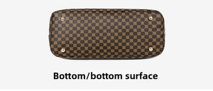 Detail view of tote bag bottom with protective gold metal studs and vintage monogram print