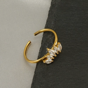 Golden crown ring with marquise-cut white zircons on dark stone and silk background