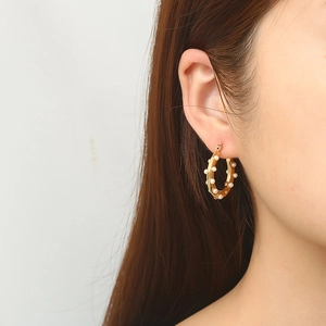 Retro stainless steel hoop earrings with pearls and 18K gold plating on female model