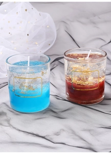 Close-up of glass candles with blue and amber wax featuring elegant gold foil flakes