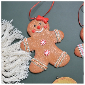 Close-up of gingerbread man Christmas ornament with red bow and glitter texture