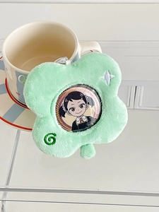 Detail view of light green clover plush badge holder with transparent window for anime pins