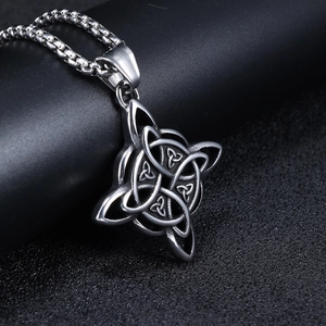 Macro shot of silver Celtic Knot pendant with metallic texture on a dark textured surface