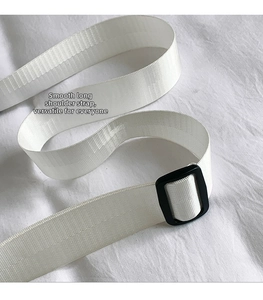 Detail of a smooth adjustable white nylon strap with a black plastic buckle on a bag