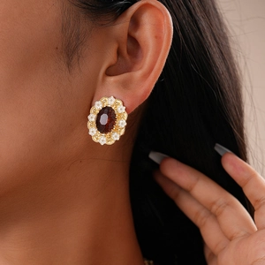 Close-up of vintage oval earring with amber gem and gold filigree on model