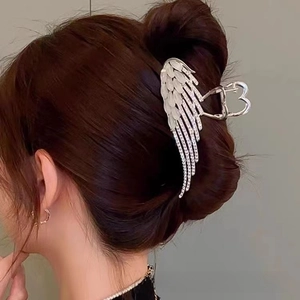 Detail of angel wing hair claw clip with opals and rhinestones on hair