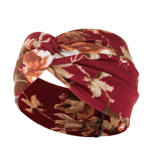 Detail of burgundy floral yoga headband with twisted knot design and elastic cotton fabric
