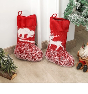 Detail of red and white knitted Christmas stockings with reindeer and house patterns