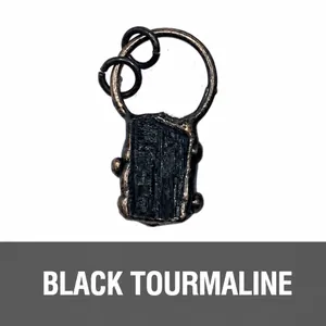 Macro view of raw black tourmaline pendant with antique bronze wire wrapping