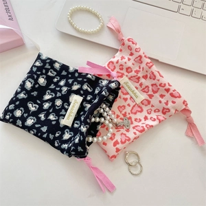 Flat lay of pink and navy heart leopard print drawstring pouches for jewelry storage