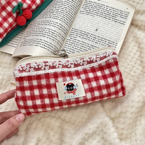 Detailed view of red plaid storage pouch with white lace trim and cat embroidery