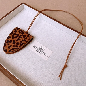 Detail view of leopard print faux leather glasses pouch necklace with fine stitching