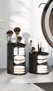 Detailed view of a black rotating makeup organizer with translucent brush storage tiers