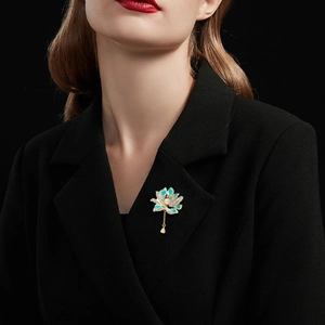 Detail of enamel lotus brooch with green petals, white pearl and dangling gold drop
