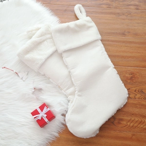 Close-up of white plush Christmas stockings with sequins on a cozy wooden floor