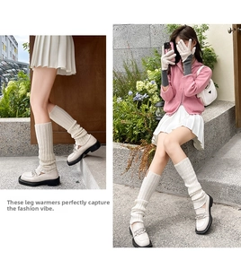 Detail of cream wool leg warmers styled with loafers and a white pleated skirt
