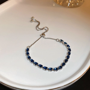 Detail of adjustable silver bracelet with square cut sapphire-blue gemstone and slider clasp