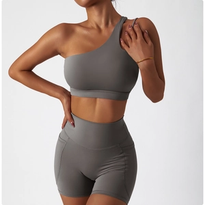Vue détaillée du soutien-gorge de sport asymétrique et du short gris avec poches latérales