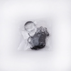 Close-up of black cross necklace and ring set in transparent plastic packaging