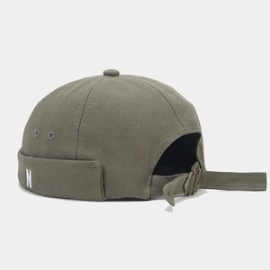 Detail of adjustable metal buckle and N embroidery on olive green canvas dock cap