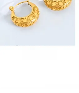 Detail of vintage golden hoop earrings with embossed hearts and textured dot patterns