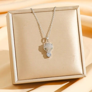 Collier avec pendentif tête de léopard serti de zircons et yeux en pierre verte