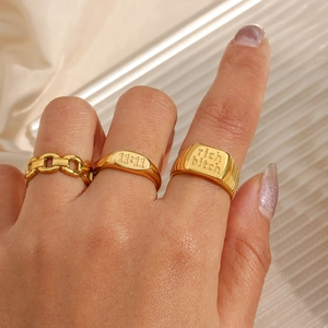 Three gold stainless steel rings featuring 11:11 engraving and chain design on silk fabric