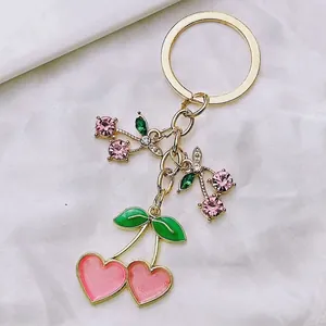 Cute pink heart-shaped cherry keychain with gold metal plating and sparkling rhinestones