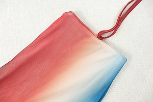 Close-up of red to blue gradient mesh fabric and drawstring detail on holiday dress