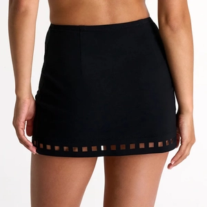 Detail of black high-waisted mini skirt featuring laser-cut geometric patterns at the hem
