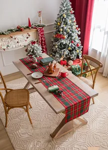 Detail of red and green plaid Christmas table runner on a festive dining table decoration