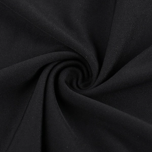 Close-up of black mesh fabric showing fine texture and soft draped pleats of the dress