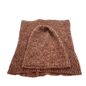 Detailopname van de geribbelde breistructuur op de roodbruine muts- en nekwarmer set
