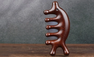 Detailansicht eines handgefertigten Sandelholz-Massagekamms mit ergonomischem Design