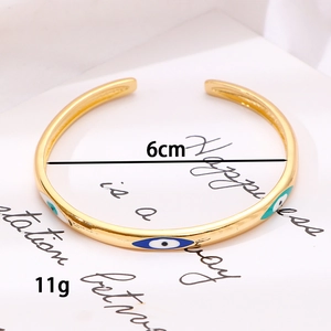 Dettaglio bracciale a C dorato con occhio greco, diametro 6cm e peso di 11 grammi