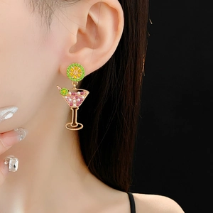 Detail of vintage gold cocktail glass earrings with colorful zircons worn by a model