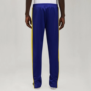 Detail view of navy blue track pants with yellow side stripes and elastic waistband