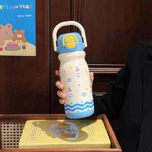 Detail of cute puppy thermos with blue lid and handle held in a lifestyle setting