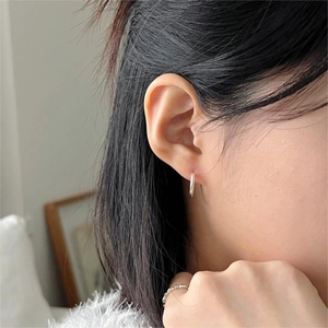 Minimalist 925 sterling silver hoop earrings with high polish finish worn by a model