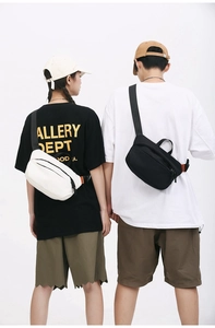 Detail view of large minimalist crossbody chest bags in black and white worn by couple models
