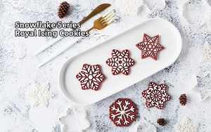 Detail showing snowflake cookies and stainless steel cutters for festive holiday baking