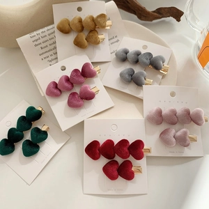 Set aus Samt-Herz-Haarklammern in Vintage-Farben wie Burgund und Grün auf Karte
