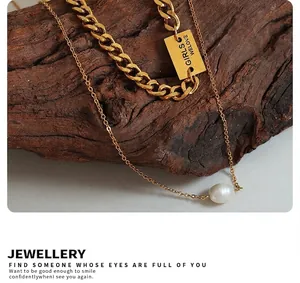 Close-up of double layer gold chain with square letter pendant and white pearl detail