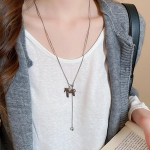 Detail of silver snake chain necklace with brown pony pendant on a model's neck