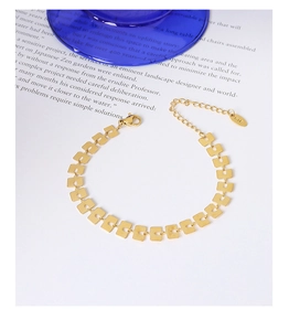 Primo piano dettagliato di un bracciale in titanio placcato oro 18k con paillette quadrate