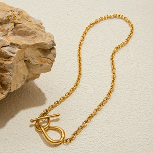 Détail d'un collier en acier inoxydable doré avec fermoir OT et maillons ovales
