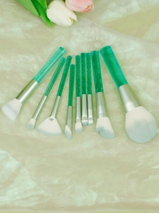 Detail of 9-piece makeup brush set with green handles and blue-tipped white bristles