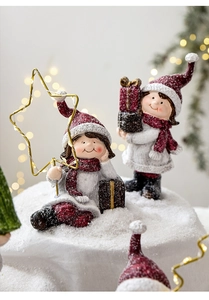 Detailed close-up of resin Christmas figures with glitter finish on festive snow background